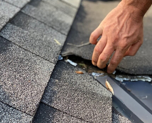 a hand touching a broken roof