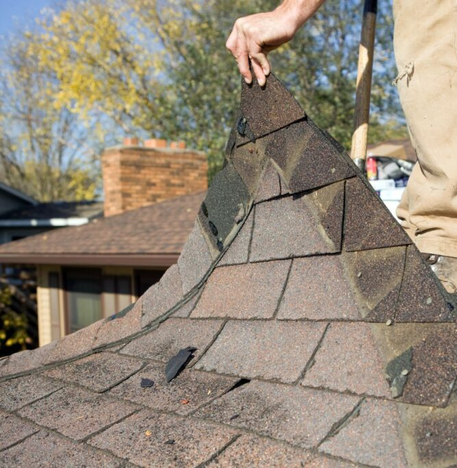 a person replacing shingles from a roof