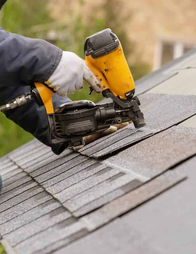 a person using a nail gun on a roof