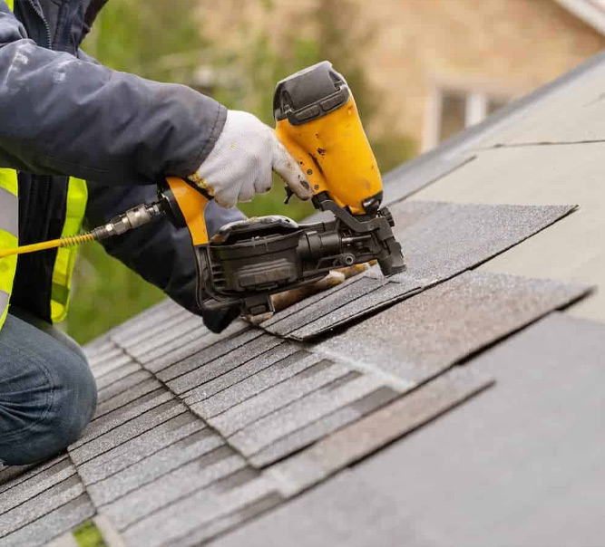 a person using a nail gun on a roof