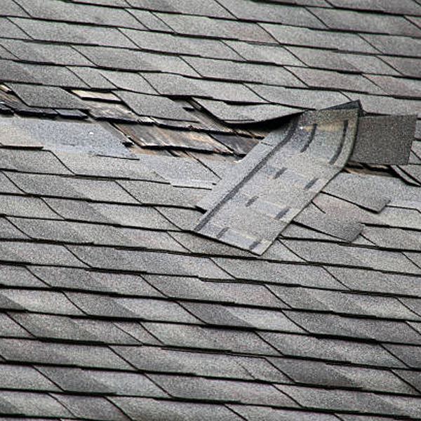 a damaged roof shingles on a roof